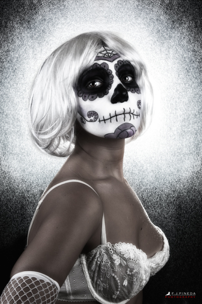 Retrato de perfil de mujer adulta con peluca blanca y maquillaje de calavera, sobre fondo claro y texturado. de F. J. Pineda