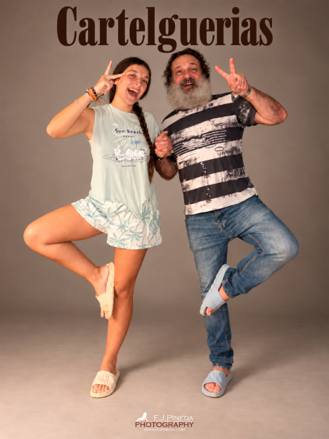 F. J. Pineda y una acompañante posan sonriendo, ambos con una pierna levantada y haciendo el gesto de la victoria, bajo el título «Cartelguerias».