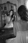 Toma falsa en blanco y negro de Chloe frente al espejo, en una escena de baño o tocador dentro de Las Habitaciones de Chloe.