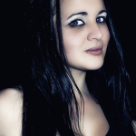 Retrato de mujer adulta con cabello negro, mirada lateral y fondo oscuro de alto contraste.
