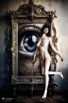 Mujer desnuda junto a un gran marco ornamentado en cuyo interior aparece un enorme ojo azul como imagen central.