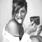 Mujer adulta en blanco y negro, sacando la lengua mientras sostiene una taza en una escena desenfadada.