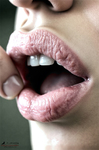 Primer plano de una boca femenina con los labios abiertos y brillo húmedo, en una imagen sensual de encuadre cerrado.