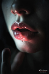 Primer plano de labios rojos con líquido o pigmento oscuro sobre la boca, en una imagen de tono dramático.