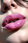 Primer plano de labios fucsia entreabiertos, con luz directa y piel clara alrededor de la boca.