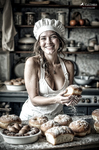 Mujer adulta con gorro de panadera sonriendo frente a una mesa llena de panes, en un ambiente rústico y cálido.