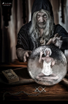Anciana con aspecto de hechicera inclinada sobre una esfera de cristal en cuyo interior aparece una pequeña figura humana.