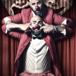 Hombre con chaqueta roja sujetando la cabeza de otro hombre con nariz roja, en una escena de dominio y humor oscuro.