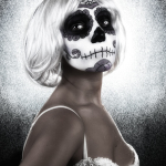 Retrato de perfil de mujer adulta con peluca blanca y maquillaje de calavera, sobre fondo claro y texturado.
