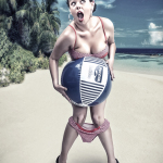 Mujer adulta en la playa, sosteniendo una gran pelota delante del cuerpo en una escena pin-up humorística.