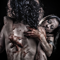 Mujer adulta de espaldas, con sangre y manos sobre el cuerpo en una escena de horror gótico.
