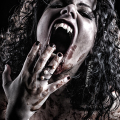 Mujer adulta gritando con sangre en la boca y las manos, en un primer plano de terror vampírico.