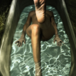 Mujer adulta descendiendo a una piscina o bañera estrecha, vista desde arriba en una composición vertical.