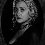 Retrato pictórico de una mujer adulta de cabello claro, vestida de negro y mirando hacia un lado sobre fondo oscuro.