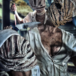 Primer plano lateral del torso y la cabeza triangular de Pyramid Head, con fuerte dramatismo y sombras.