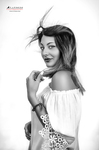 Retrato en blanco y negro de mujer adulta con blusa clara caída sobre los hombros, girando el rostro hacia la cámara.