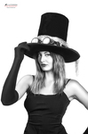 Retrato en blanco y negro de mujer adulta con sombrero de copa, tocando el ala con una expresión seria.