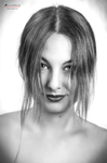 Primer plano en blanco y negro de mujer adulta con el cabello cayendo sobre el rostro y mirada intensa.