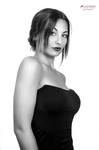 Retrato en blanco y negro de mujer adulta con vestido negro de tirantes, mirando a cámara de frente.