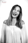 Retrato en blanco y negro de mujer adulta con blusa clara, inclinando la cabeza y sonriendo.