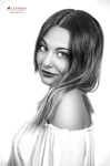 Retrato en blanco y negro de mujer adulta con blusa clara, girada de perfil parcial y expresión delicada.