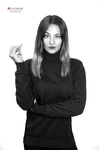 Retrato en blanco y negro de mujer adulta con jersey oscuro, de pie y con expresión seria.