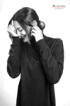 Retrato en blanco y negro de mujer adulta con jersey oscuro, tocándose el cabello cerca de la sien.