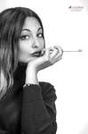 Retrato en blanco y negro de mujer adulta con jersey oscuro, sosteniendo un cigarrillo con gesto elegante.