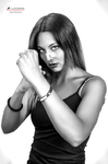 Retrato en blanco y negro de mujer adulta con top oscuro, cruzando los brazos en una pose firme.