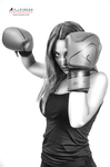 Retrato en blanco y negro de mujer adulta con guantes de boxeo levantados, en pose combativa.