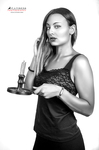 Retrato en blanco y negro de mujer adulta sosteniendo una palmatoria, bandeja o soporte con objetos.