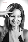 Retrato en blanco y negro de mujer adulta haciendo una mueca con los dedos junto al rostro.