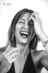 Retrato en blanco y negro de mujer adulta riendo abiertamente, con una mano en la frente.