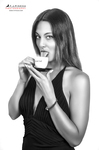 Retrato en blanco y negro de mujer adulta sosteniendo una taza pequeña cerca de la boca.