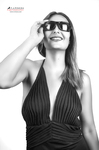 Retrato en blanco y negro de mujer adulta con vestido oscuro de cuello halter, mirando hacia arriba con una sonrisa.