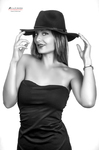 Retrato en blanco y negro de mujer adulta con sombrero oscuro, tocando el ala con una sonrisa leve.