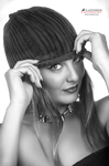 Retrato en blanco y negro de mujer adulta con flequillo corto o gorro, ajustándolo con una mano.