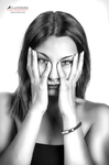 Primer plano en blanco y negro de mujer adulta enmarcando los ojos con ambas manos.