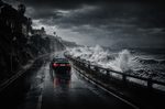 Coche negro circulando por una carretera costera mojada, con el mar embravecido golpeando el muro y nubes oscuras sobre la costa.