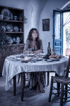 Alina sentada ante una mesa antigua en Casa Salobre, rodeada de platos, cerámica y luz mediterránea.