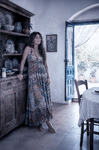 Alina de pie junto a una puerta azul en una estancia antigua de Casa Salobre, vestida con ropa bohemia.