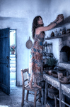 Alina estirando el brazo para alcanzar objetos en una alacena antigua dentro de la cocina de Casa Salobre.