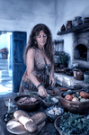 Alina sentada entre alimentos, platos y cerámica en una cocina mediterránea de Casa Salobre.