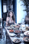 Alina sentada ante una mesa llena de platos y alimentos en el patio interior de Casa Salobre.