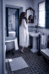 Alina de pie ante el lavabo y el espejo del baño antiguo de Casa Salobre.