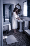 Alina junto al lavabo del baño antiguo de Casa Salobre, en una escena íntima y cotidiana.