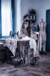Alina sentada en el cuarto de costura de Casa Salobre, rodeada de telas, luz y objetos antiguos.