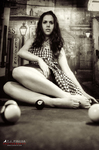 Fotografía en blanco y negro de Marina sentada junto a una mesa de billar, con bolas en primer plano.
