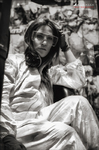 Ros Vélez sentada con ropa clara en un entorno urbano deteriorado, en una fotografía en blanco y negro.