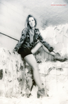 Ros Vélez sentada contra una pared clara, con ropa estampada y estética desgastada en blanco y negro.